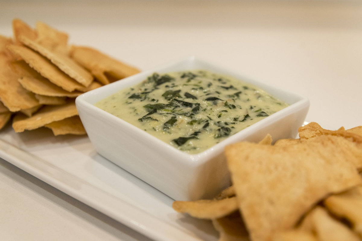 Creamy spinach dip served in a ceramic bowl.