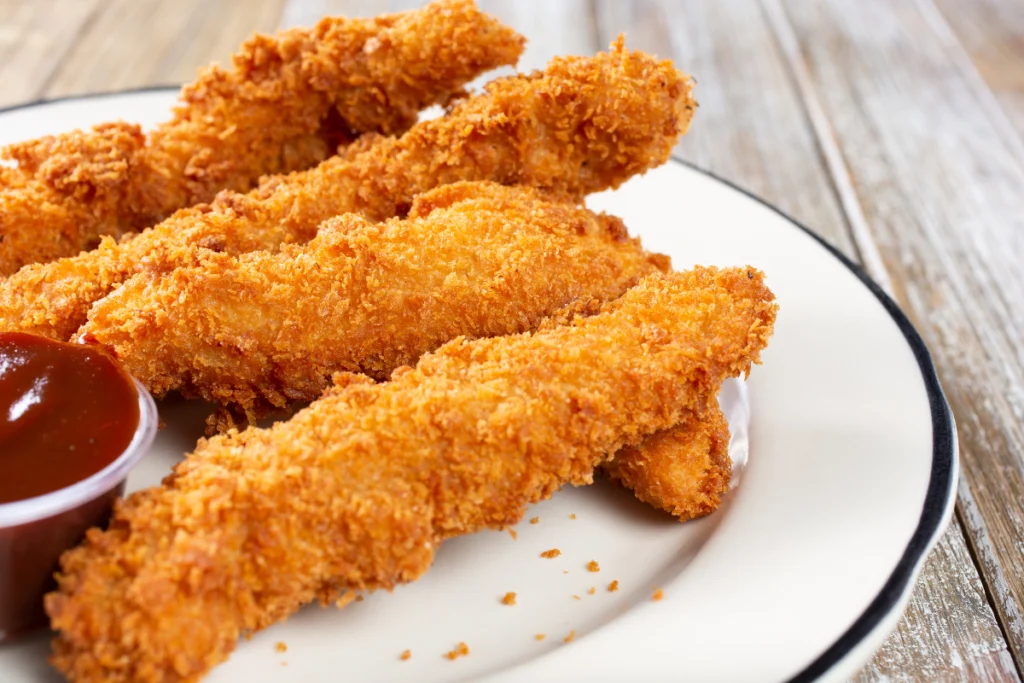 Golden brown chicken tenderloins on a white plate